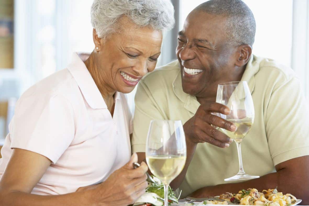 A senior couple laughing and enjoying a meal together
