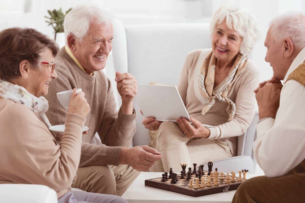 Seniors sit around a chess board