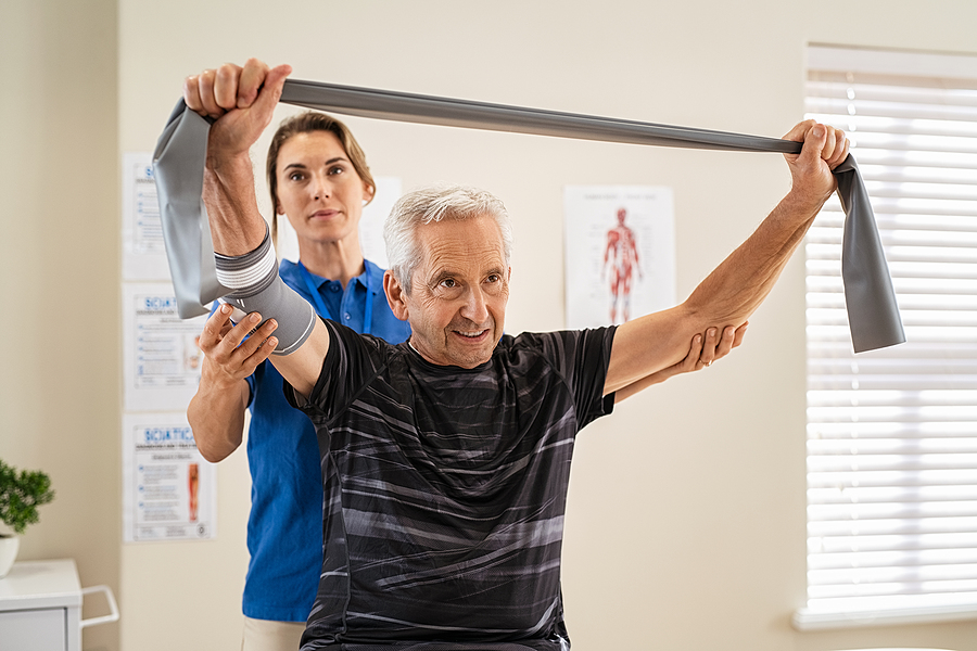 A senior patient works with a young physical therapist in senior rehabilitation. A senior patient works with a young physical therapist in senior rehabilitation.
