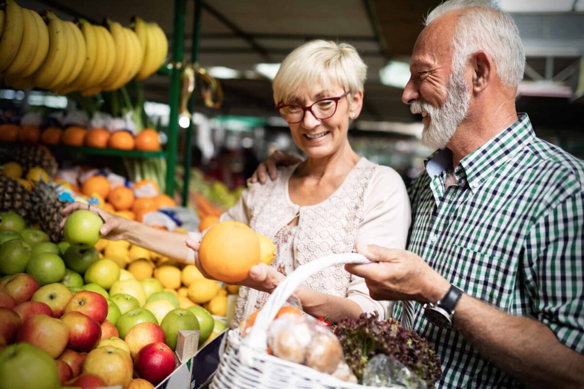 A senior man and a senior woman shopping at the outdoor market