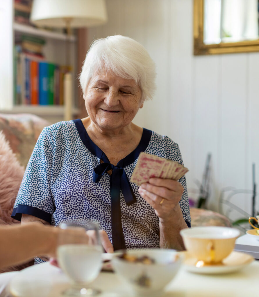 Senior woman and her adult daughter playing cards at home