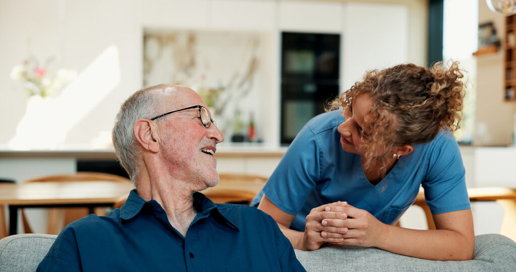 Happy, old man and talking to caregiver, nursing home and listen to elderly patient with funny story. Assisted living, senior person and conversation with woman, smile and bonding with nurse on break