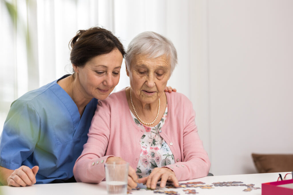 Therapy - Senior woman playing jigsaw puzzle in nursing home