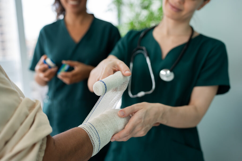 nurse wrapping a patients arm with a bandage