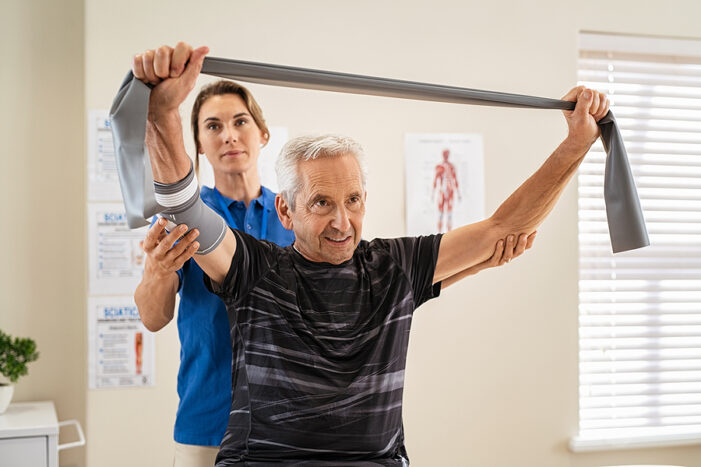 A senior patient works with a young physical therapist in senior rehabilitation.