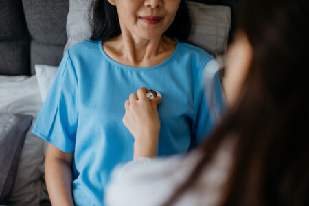 Doctor using stethoscope and examining patient