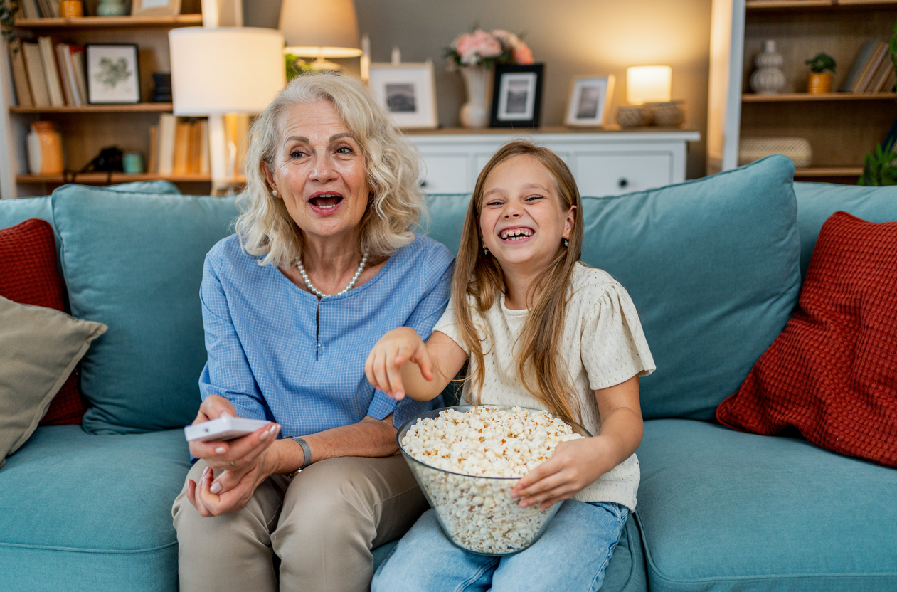 An older adult watching a movie with a grandchild